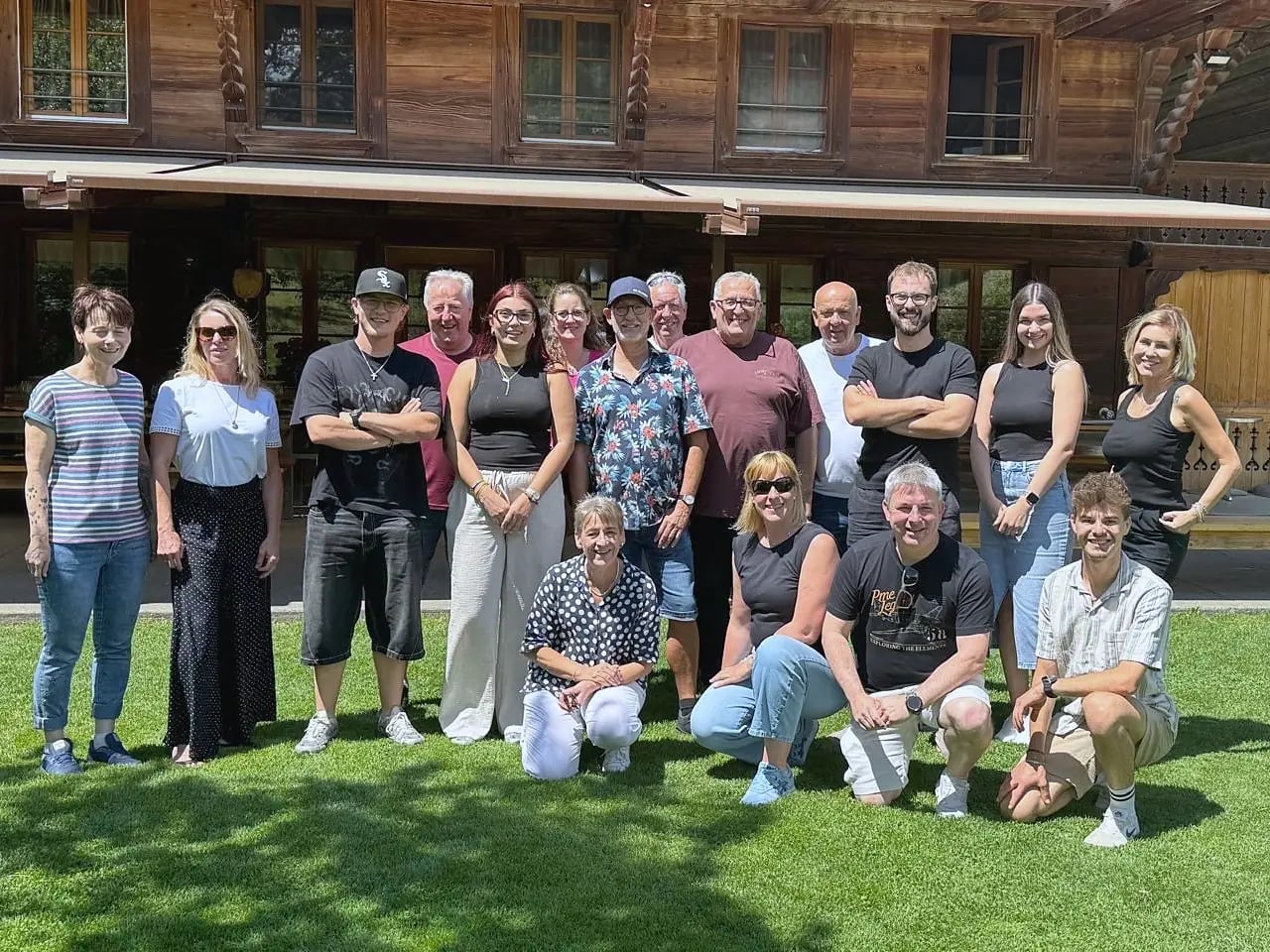 Das Team von Pfeiffertextil auf einer Wiese vor einem Holzhaus
